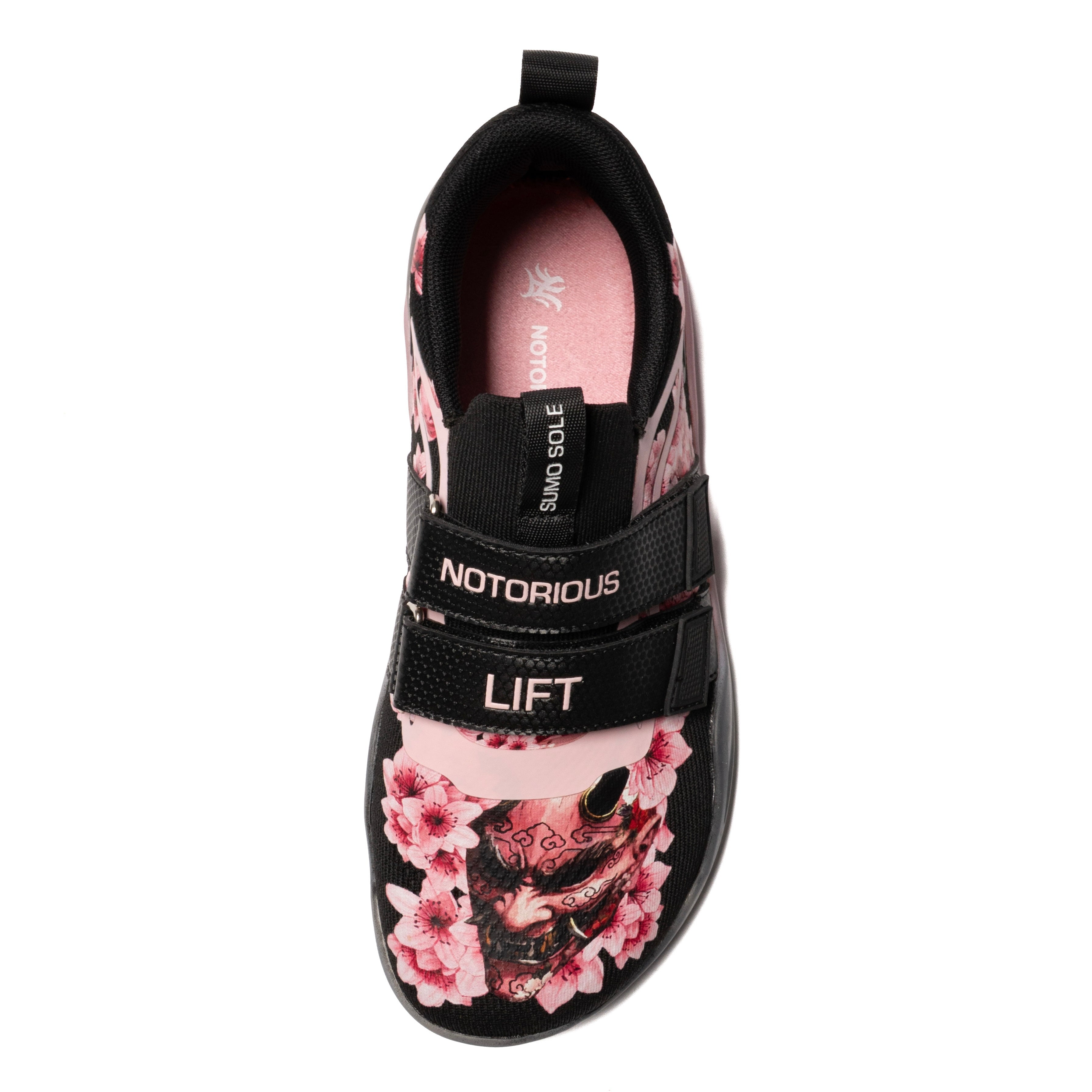 Black sneaker with pink floral design and 'Notorious' branding on a white background